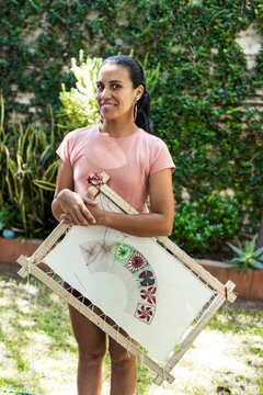 Hispanic artisan showcasing handcrafted lace textile