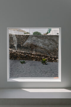 View framed by square window that captures an arid, modern landscape