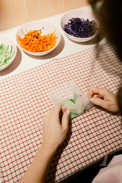 Young woman makin a spring rolls for dinner.