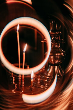 Candles and brass lamp glow in a dimly lit room