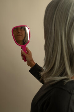 Woman Looking In Hand Mirror