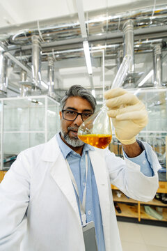 Male scientist holding vaccine vial in laboratory, UGC style.