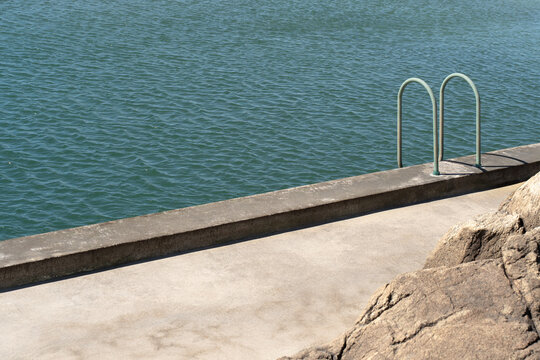 Ocean ladder on concrete pier in minimal composition
