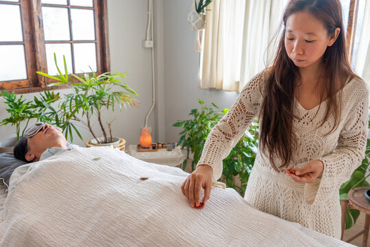 A Woman Attends to a Person Lying Down on a Bed