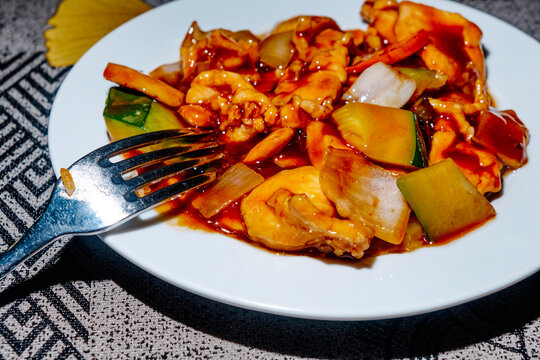 close-up of chinese chicken with almonds on a white plate