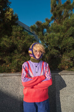 Woman in colorful sweater and knitted hood standing outdoors