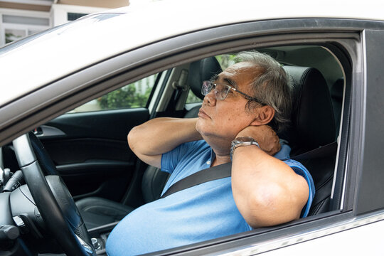 View from the street of the older man rubbing his aching neck