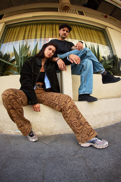 Couple posing on steps in urban setting during daytime