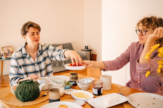 Two Women Share Breakfast at a Table in a Cozy Home Setting