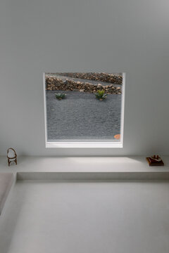 Seen through a square window frame, a dry modern landscape
