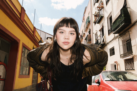 Young woman poses in vibrant city neighborhood during springtime