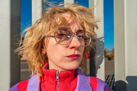 Close-up portrait of woman with glasses by vertical columns