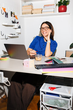 Woman Smiling at Her Home Office Workspace