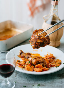 Delicious grilled chicken pieces served with carrots on a plate