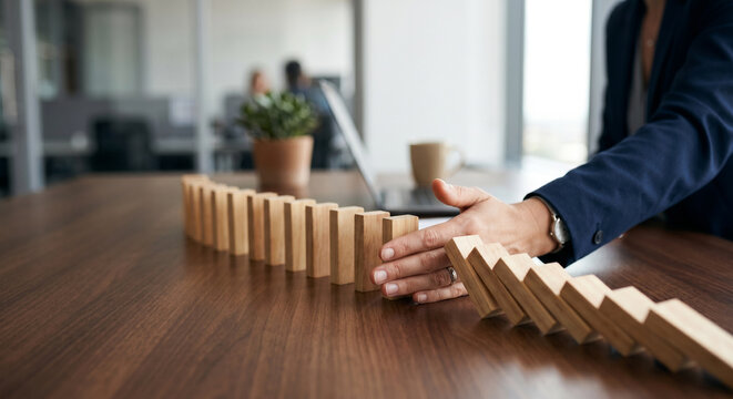 Risk management concept with hand stopping falling dominoes, crisis prevention, business continuity, operational stability, strategic planning, loss mitigation, corporate protection, decision making