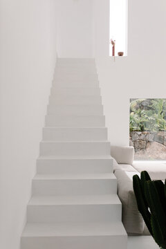Minimalist staircase connecting the living room to the upper floor