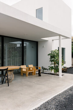A compact outdoor terrace beside a contemporary minimalist house