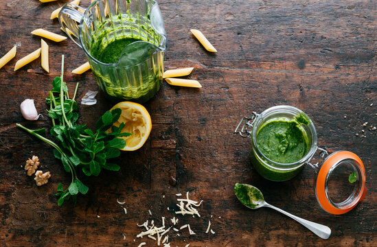 Preparation of green pesto sauce with herbs, lemon, garlic, and nuts