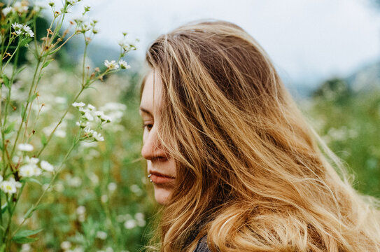 Woman portrait in wildflower meadow with soft natural light