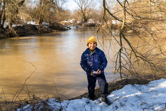 Happy child enjoying snowy day by the river