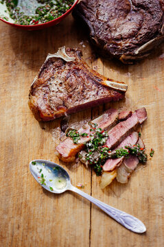 Sliced beef steak with herbs on wooden table