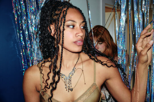 Woman holding metallic streamers at indoor party