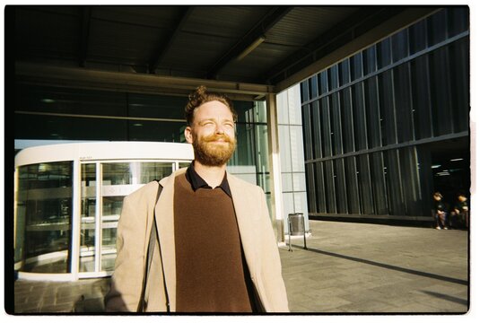 Man Smiles and Walks Outside office building