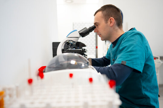 Scientist uses microscope on lab samples