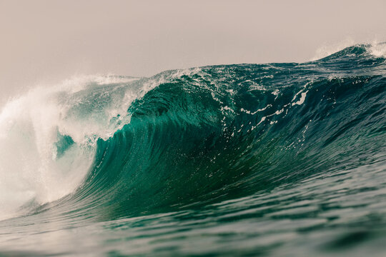 Massive wave crashing against the open ocean