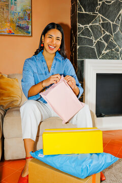 Woman unboxing online shopping package with a big smile ugc