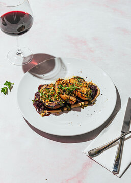 Vegan roasted "meat" alternative on creamy dip with glass of wine