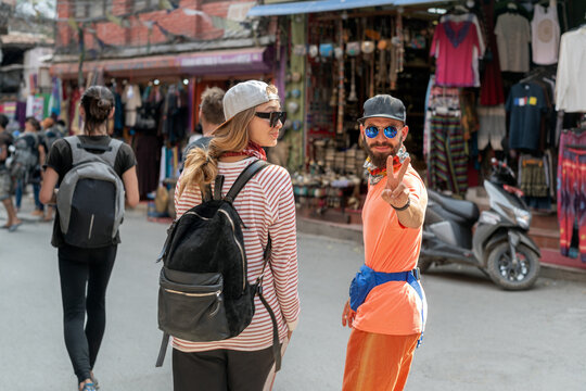 Young backpackers exploring local street market 