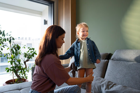 Parent dressing child at home morning routine
