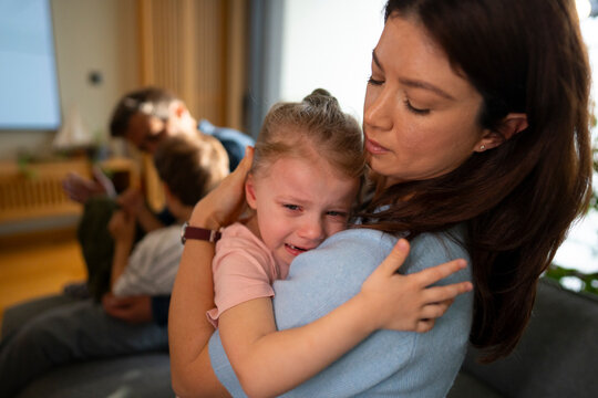 Mother comforting crying daughter at home