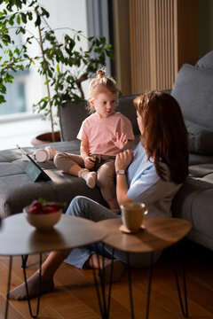 Mother teaching child numbers at home with tablet