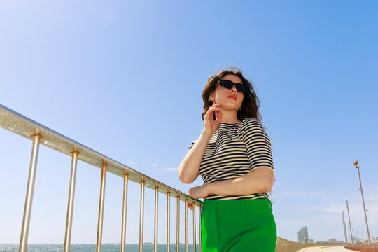 Woman Poses by the Sea on a Sunny Day