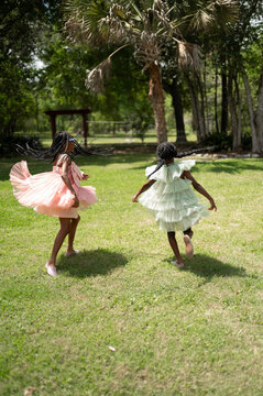 Kids Running in a Park Wearing Colorful Dresses on a Sunny Day