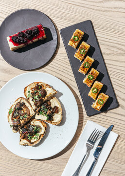 Overhead shot of sushi, mushroom toast and berry cake