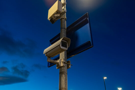 CCTV Device Mounted on Pole Against Blue Sky at Sunrise With Clouds