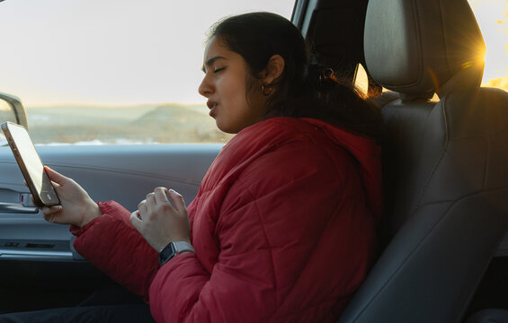 Girl singing along on a sunset drive 