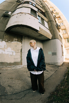 Person Stands Near Old Building With Large Concrete Design