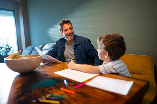 Child drawing while father works in background