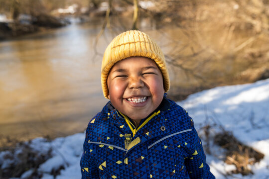 Happy child enjoying snowy day by the river