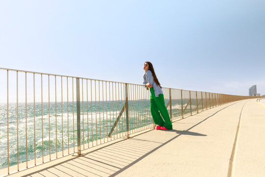 Woman Stands by the Sea Looking at the Horizon