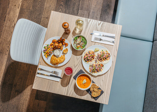 Group shot of food on dining table with chair and bench