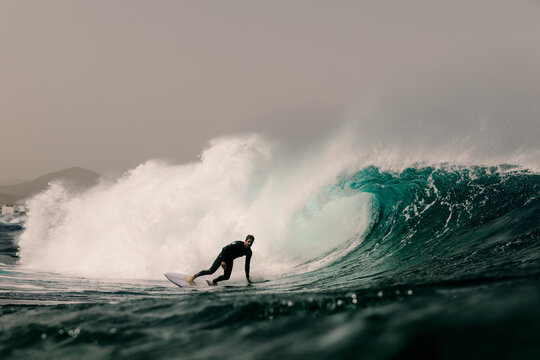 Experienced surfer moves across a towering ocean swell while training