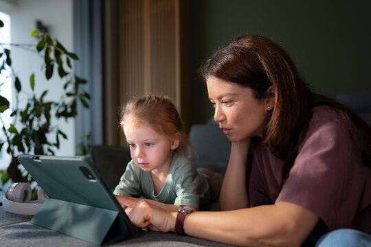 Mother and child focus on tablet together