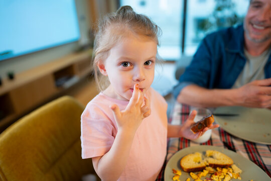 Girl enjoys snack while sitting at the table