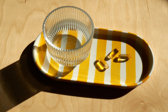 Three fish oil capsules on a tray