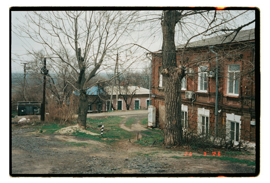 Film Photo &ndash; Old Brick Buildings on Dirt Road in Provincial Town
